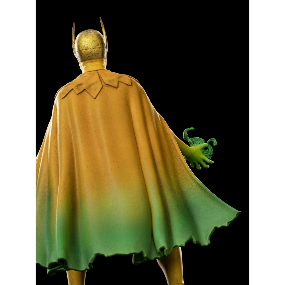 Una figura con elmetto e mantello dorati, sfumato dal giallo al verde, tiene un globo verde. Lo sfondo è nero.