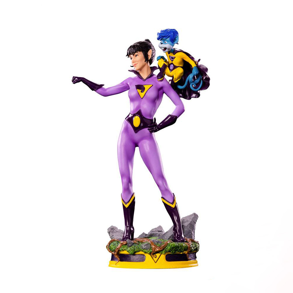 Una statua di una donna in tuta viola con un'emblema giallo. Una creatura blu è seduta sulla sua spalla. Sono su una base gialla.