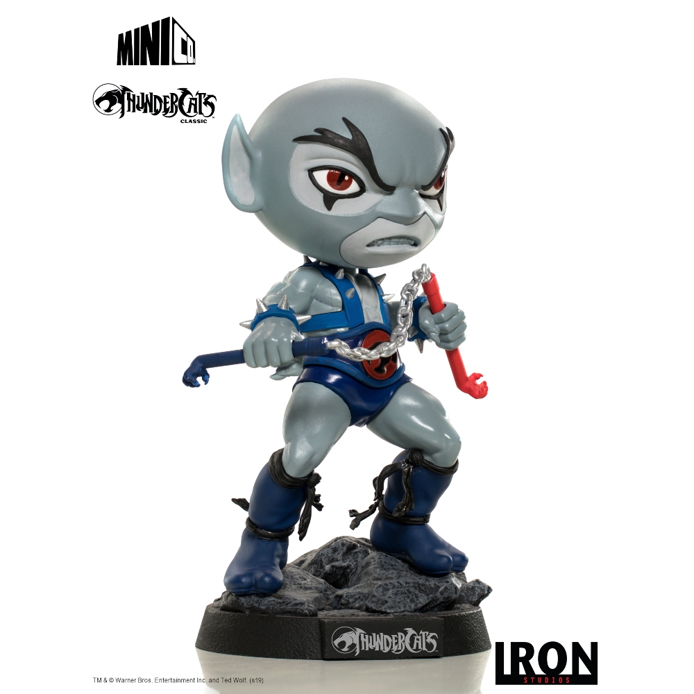 Una statuina dei Thundercats. Ha una testa grigia, un completo blu e tiene una catena e un gancio rosso. Si trova su una base rocciosa.