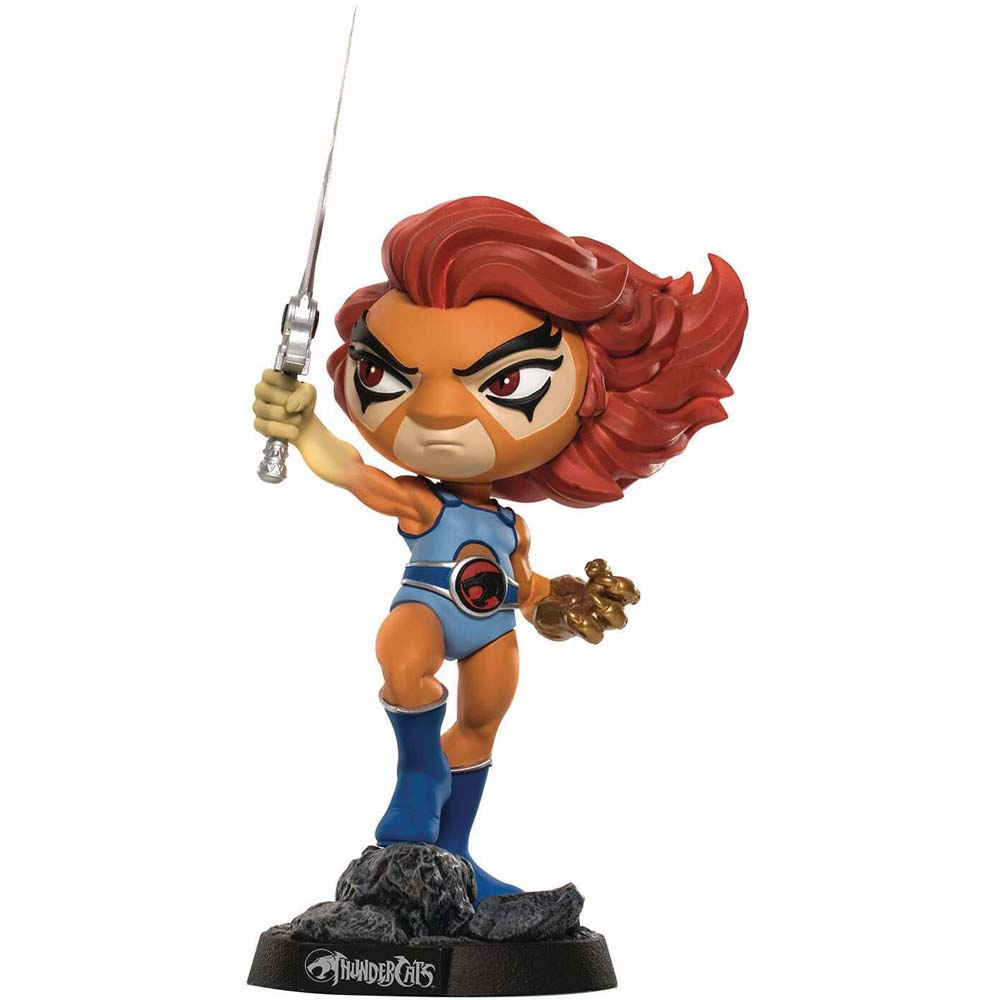 Una statuetta di Lion-O che tiene una spada. Indossa un abito blu e ha i capelli rossi. La base dice 'ThunderCats'.
