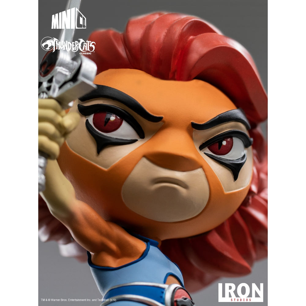 Statua di Lion-O dei Thundercats. Ha i capelli rossi, la faccia arancione e tiene una spada. La figura indossa un top blu.