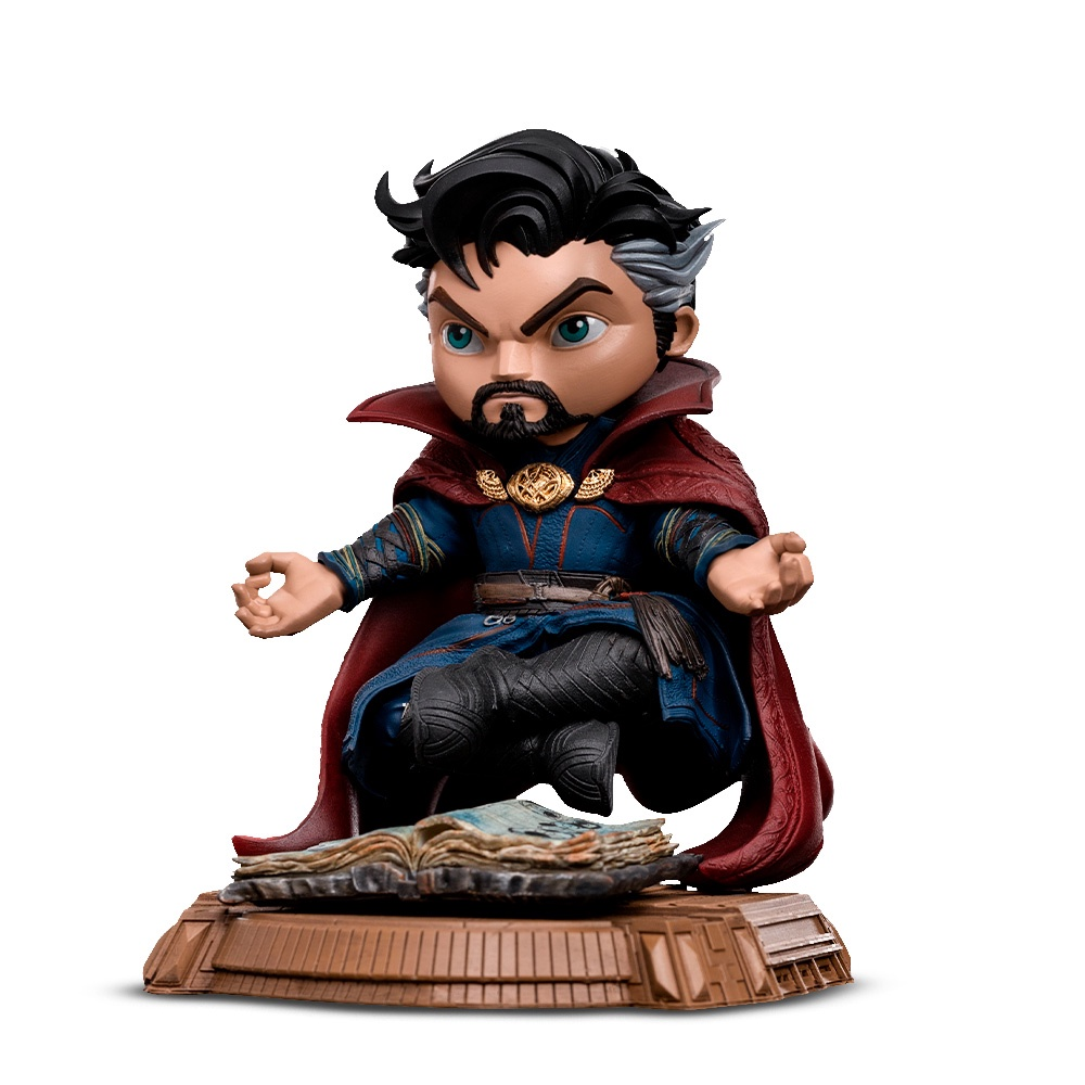 Una statuetta di Doctor Strange. Siede su una base con un libro aperto. Indossa un mantello rosso e un abito blu, con espressione severa.