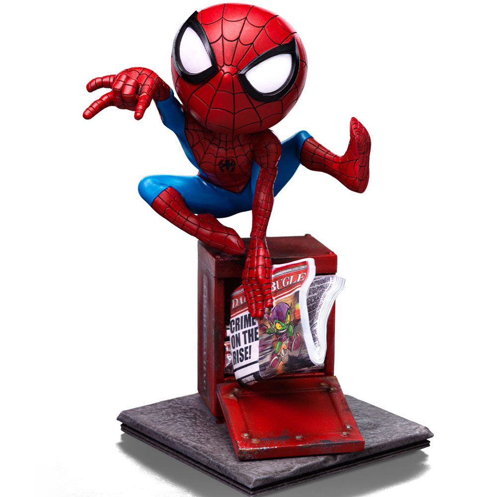 Una statuetta di Spider-Man, rossa e blu, appollaiata su un'edicola rossa. Un giornale con un'illustrazione di Goblin è visibile.