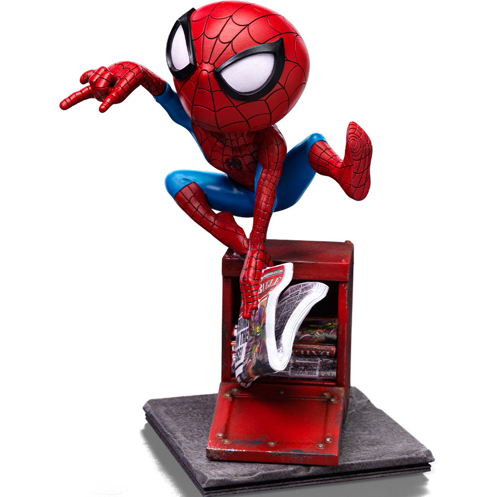 Statuina di Spider-Man appollaiata su un'edicola rossa, con un giornale in mano. La figura è rossa e blu, con testa stilizzata e grandi occhi.