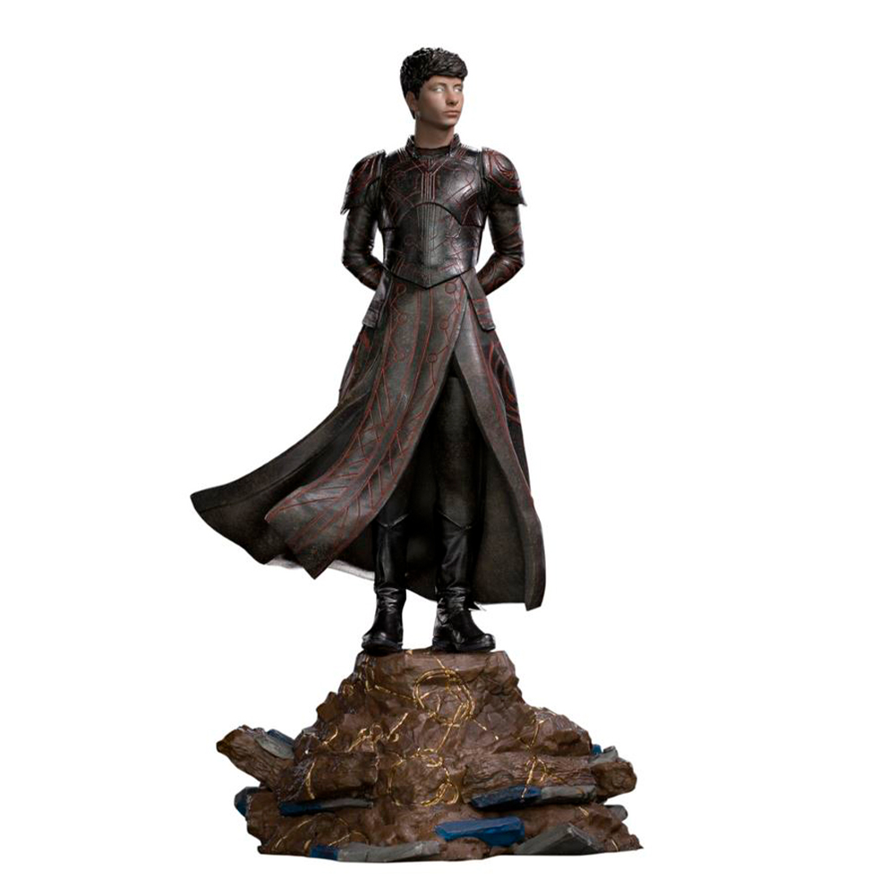 Una statua di una persona con un'armatura scura e un cappotto svolazzante, in piedi su una base rocciosa. La figura ha i capelli corti e le mani dietro la schiena.