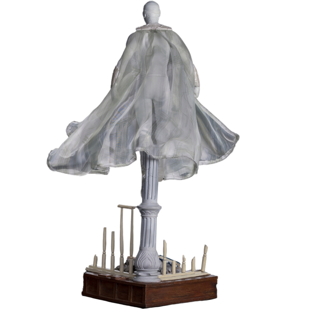 Una scultura di una figura con un mantello fluente, in piedi su una colonna. La base è in legno, con piccoli pali.