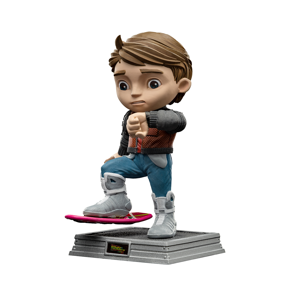 Una statuetta di Marty McFly su un hoverboard. Indossa una giacca e jeans. La figura è su una piattaforma grigia con il logo 'Ritorno al futuro'.
