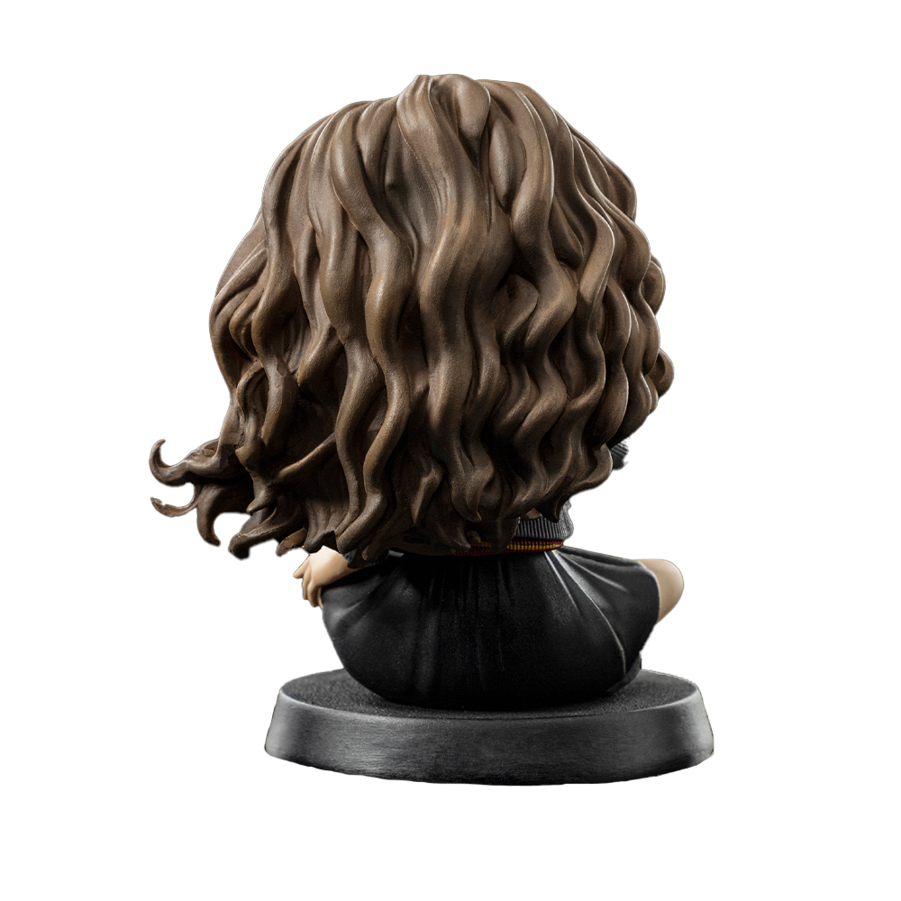 Una statuetta di Hermione vista da dietro, con capelli castani ricci. Indossa una veste nera. La statuetta è su una base nera.