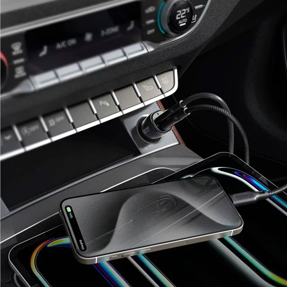 A phone is charging in a car. There are buttons for A/C, parking, and other car functions.