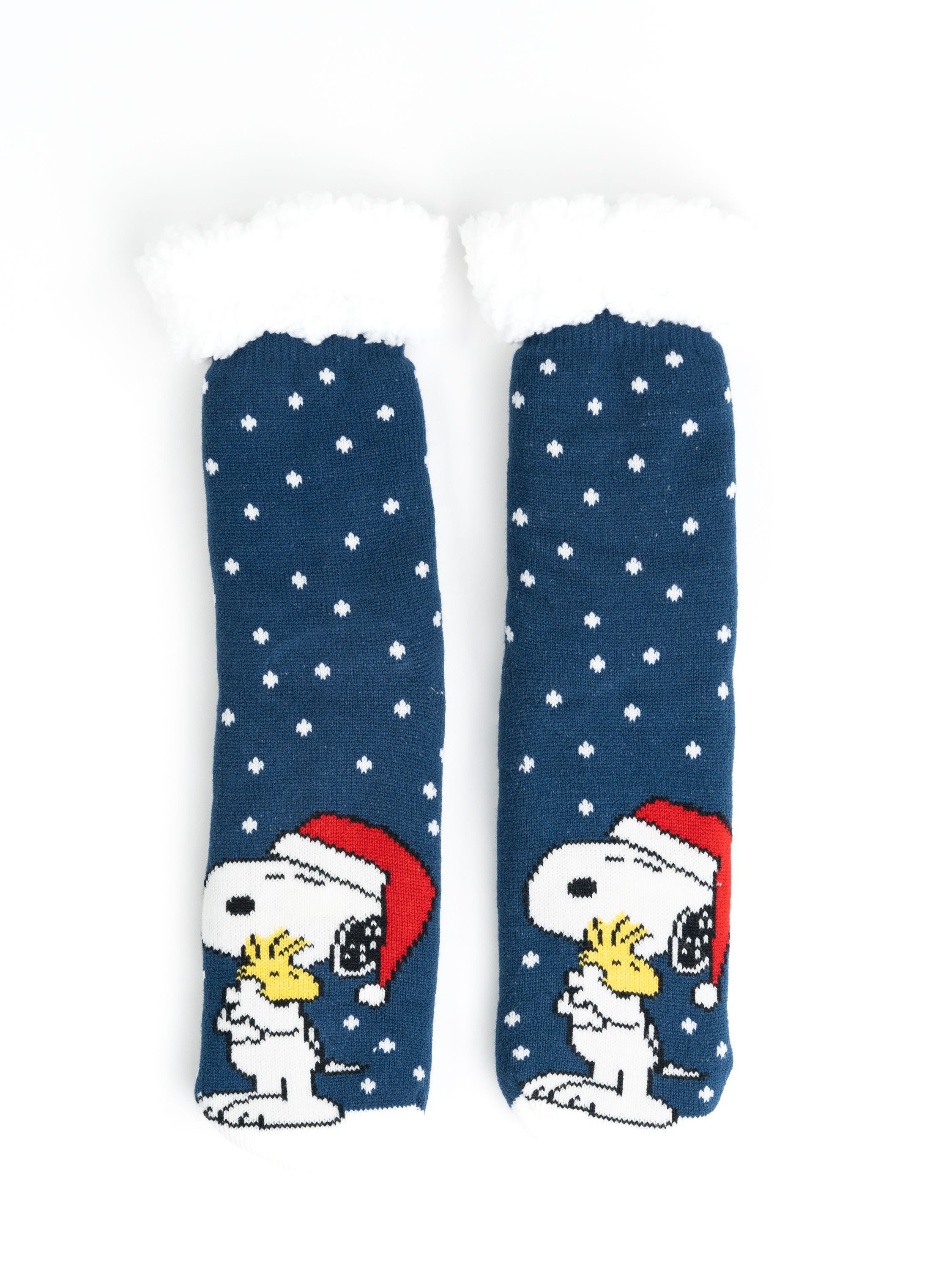 Zwei blaue Socken mit Snoopy in Weihnachtsmützen auf weißem Hintergrund. Jede Socke hat weiße Schneeflocken.