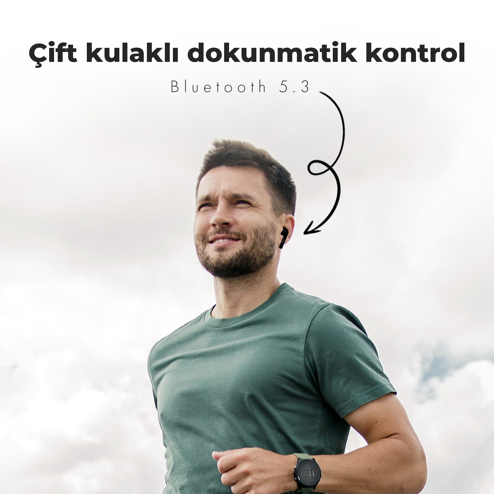 Yeşil tişört ve akıllı saat takan koşan bir adam. Kulaklarında siyah kulaklıklar. Arka planda bulutlu gökyüzü.