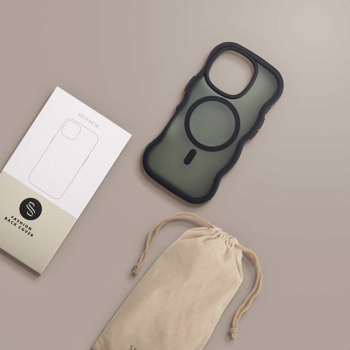 Un étui pour iPhone, une boîte avec un contour de téléphone et un sac à cordon sont sur une surface marron. L'étui est noir et le sac beige.