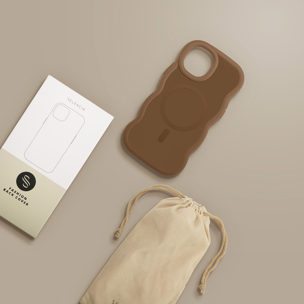 Een bruine telefoonhoes, een witte doos met een telefooncontour en een beige zakje met een trekkoord liggen op een lichtbruin oppervlak.