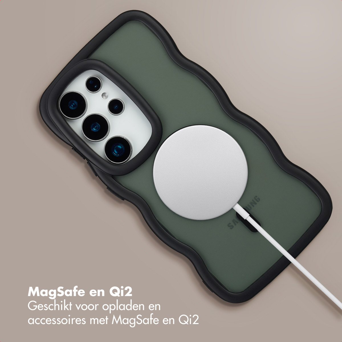 Een groene telefoonhoes met zwarte rand. Een witte oplader is bevestigd. Tekst onderaan: 'MagSafe en Qi2'.