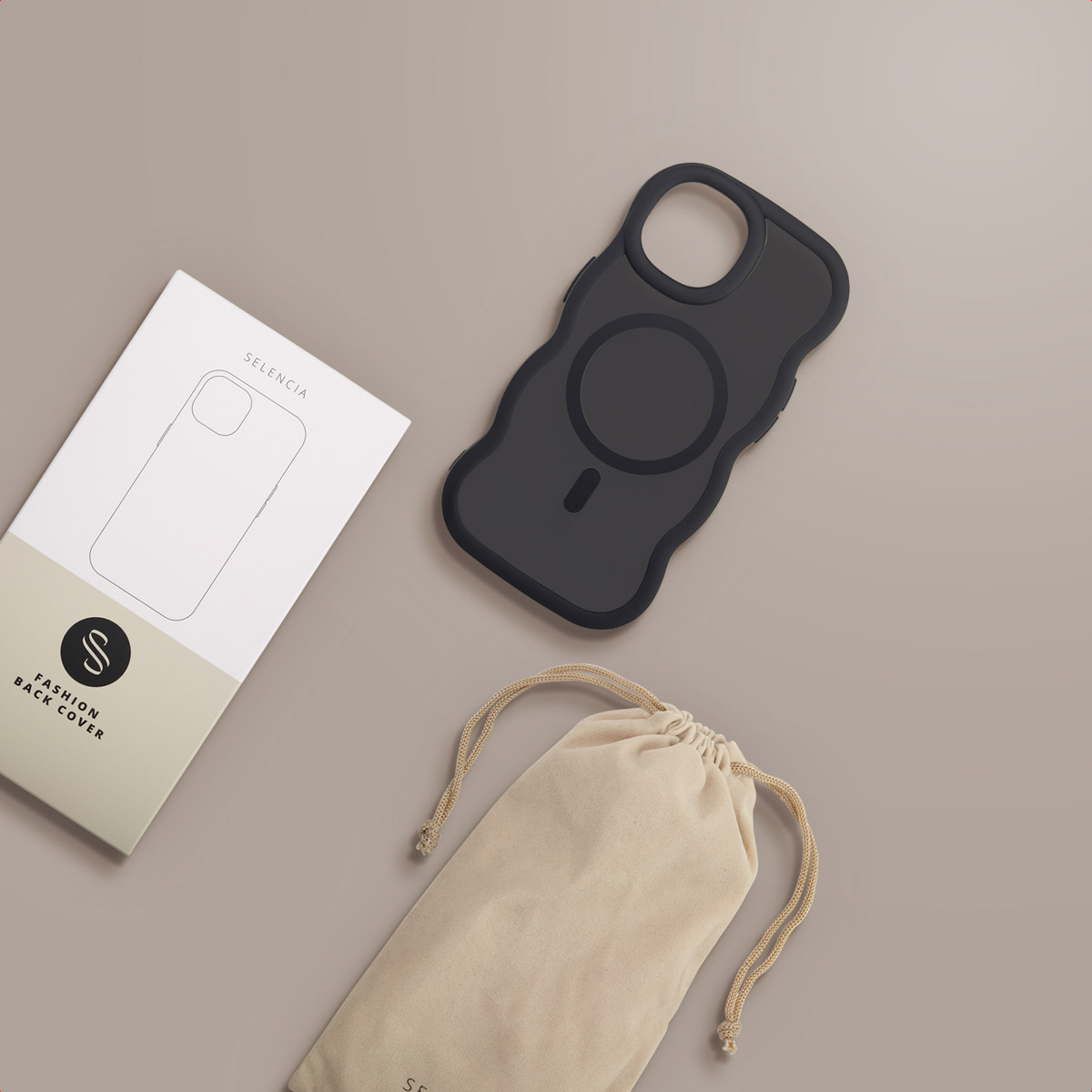 A black phone case, a white box with phone outline, and a beige bag are arranged on a beige surface.