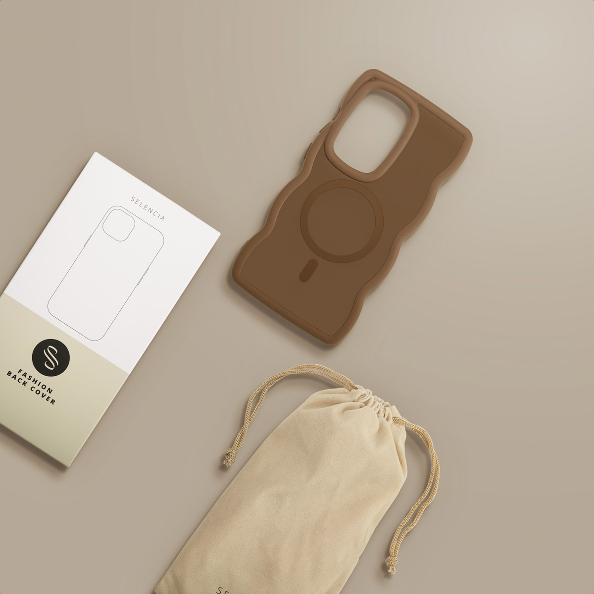 Een bruine telefoonhoes, witte doos en beige zakje met trekkoord op een beige ondergrond. De hoes heeft een golvend ontwerp.