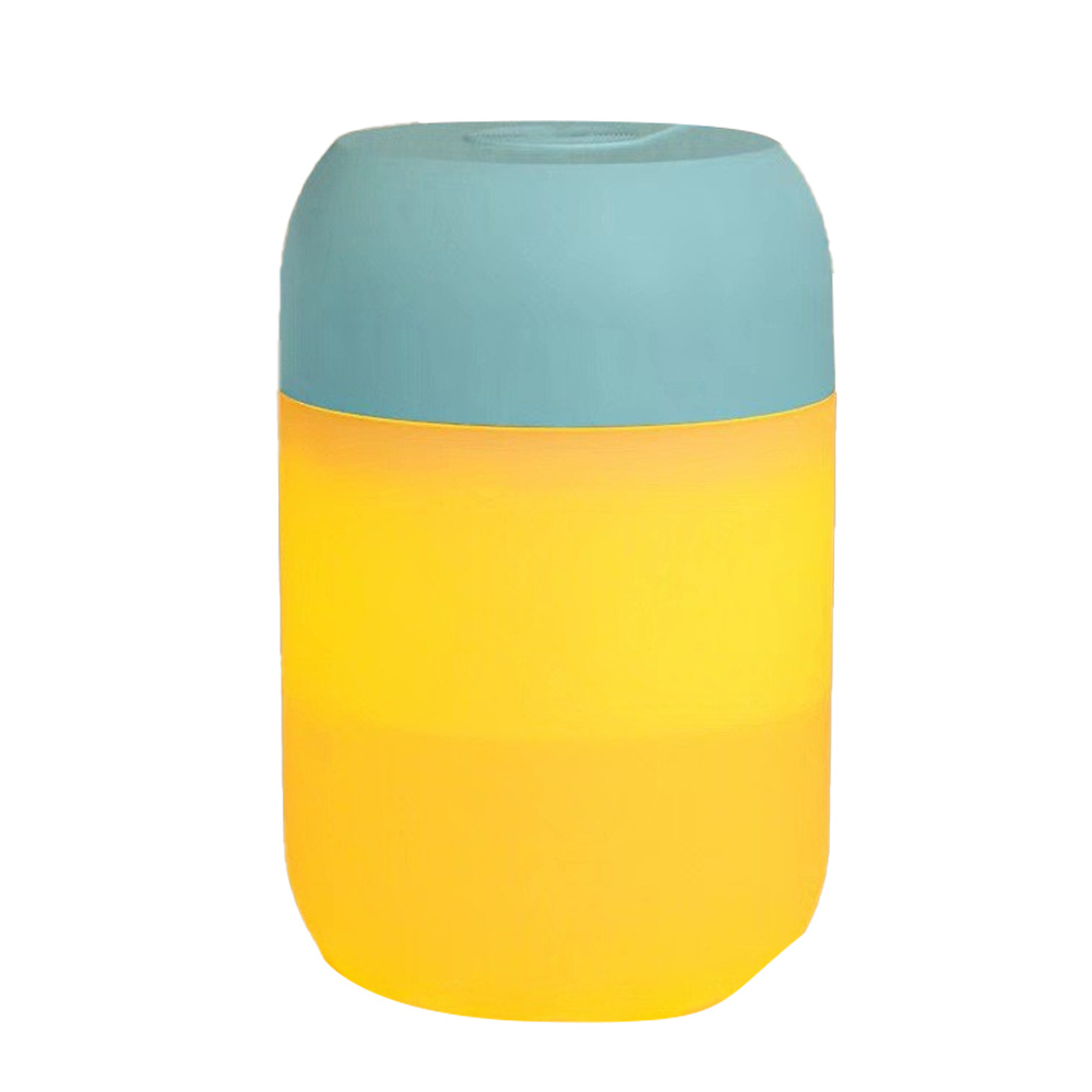 Eine zylindrische Lampe mit tealfarbenem Oberteil und gelbem Körper. Die Lampe leuchtet und steht vor einem weißen Hintergrund.