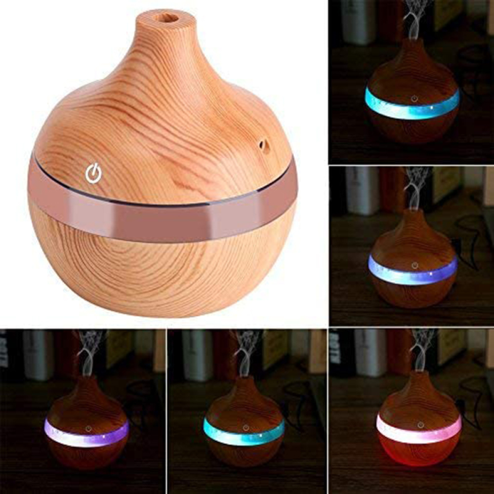 Holz-Duftzerstäuber mit Lichtring. Mehrere Lichteinstellungen: blau, lila, weiß und rot. Dampf tritt oben aus.