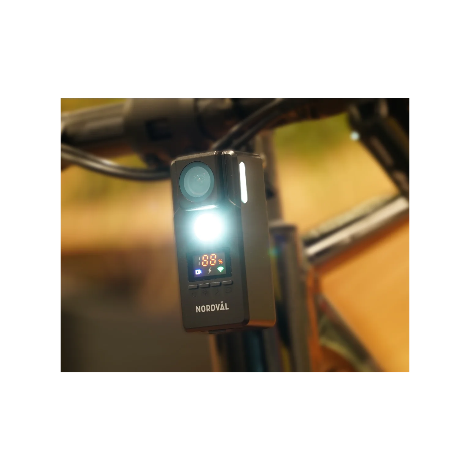 A black Nordval bike light with a bright LED. It is mounted on a bike's handlebar. The screen displays battery life and other icons.