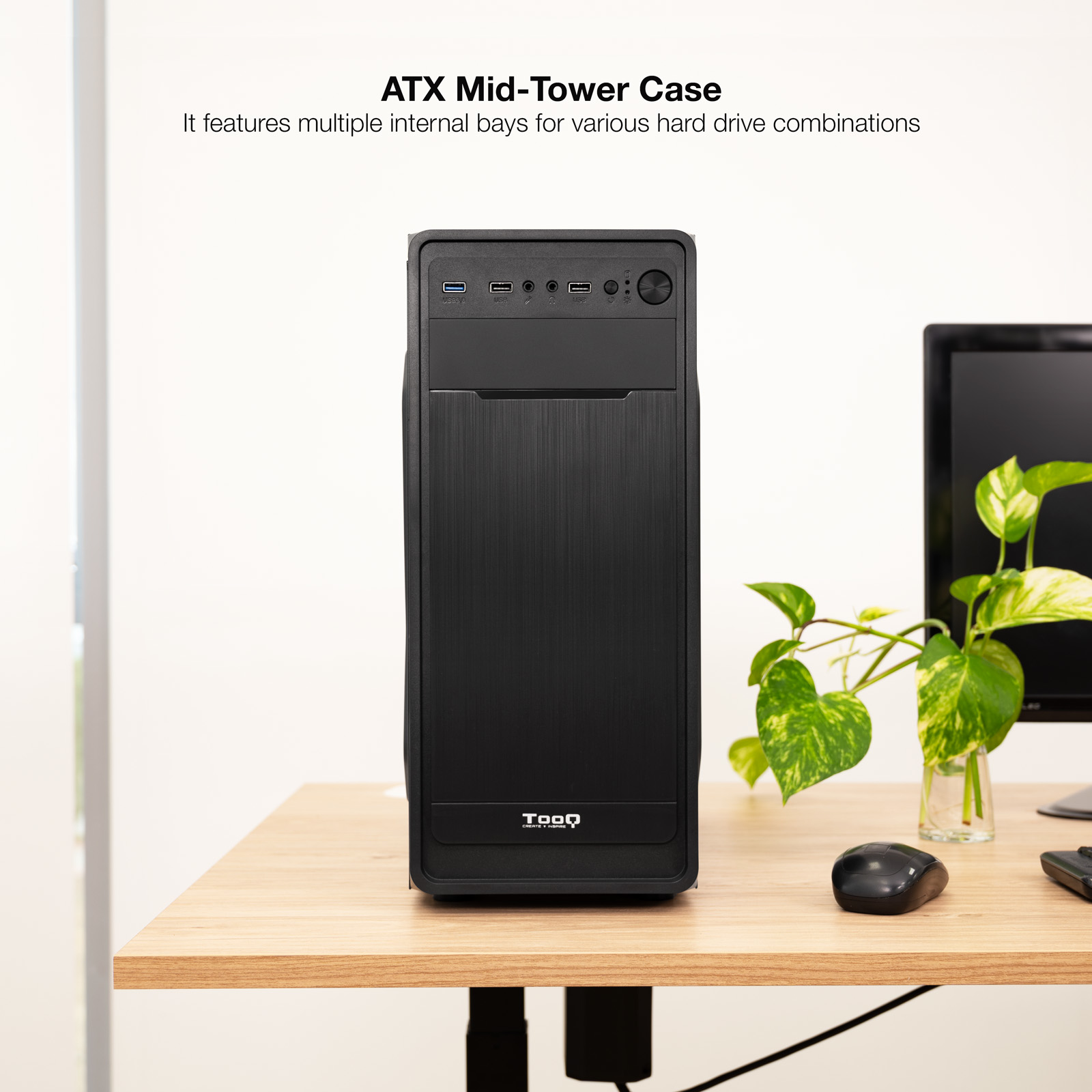Case per computer ATX Mid-Tower nero su un tavolo di legno, con mouse, monitor e pianta.