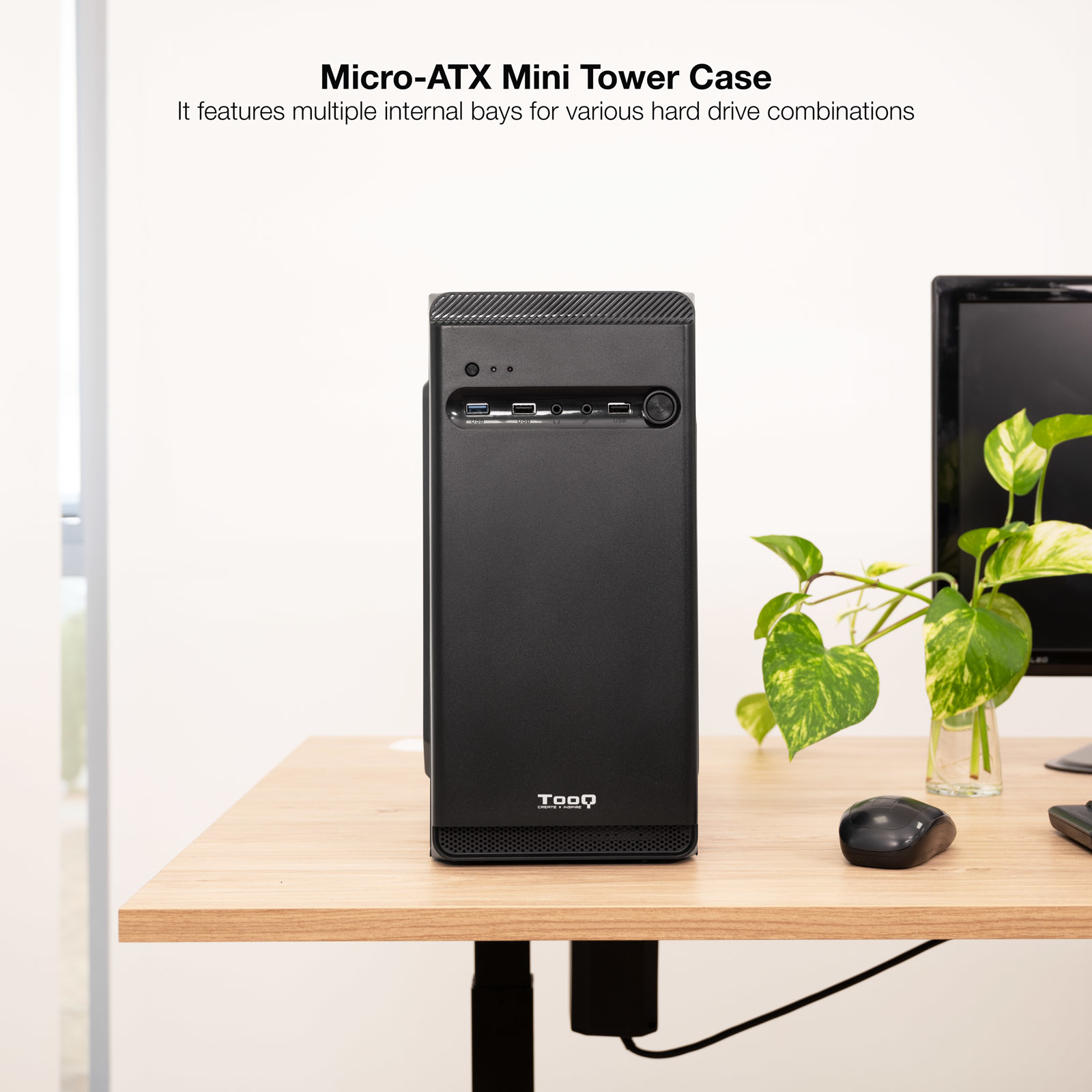 Czarna obudowa Micro-ATX Mini Tower na drewnianym biurku. Obecny jest również ekran komputera, roślina i mysz.