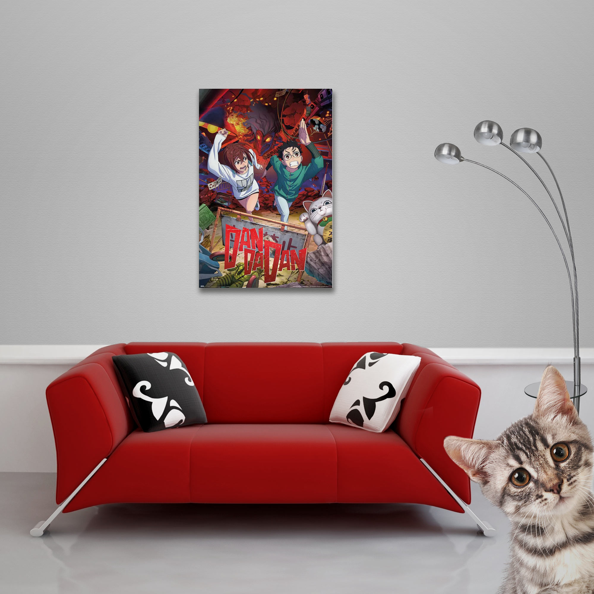 Rotes Sofa mit Kissen, Anime-Poster, silberne Lampe und eine neugierige Katze, die den Betrachter ansieht.