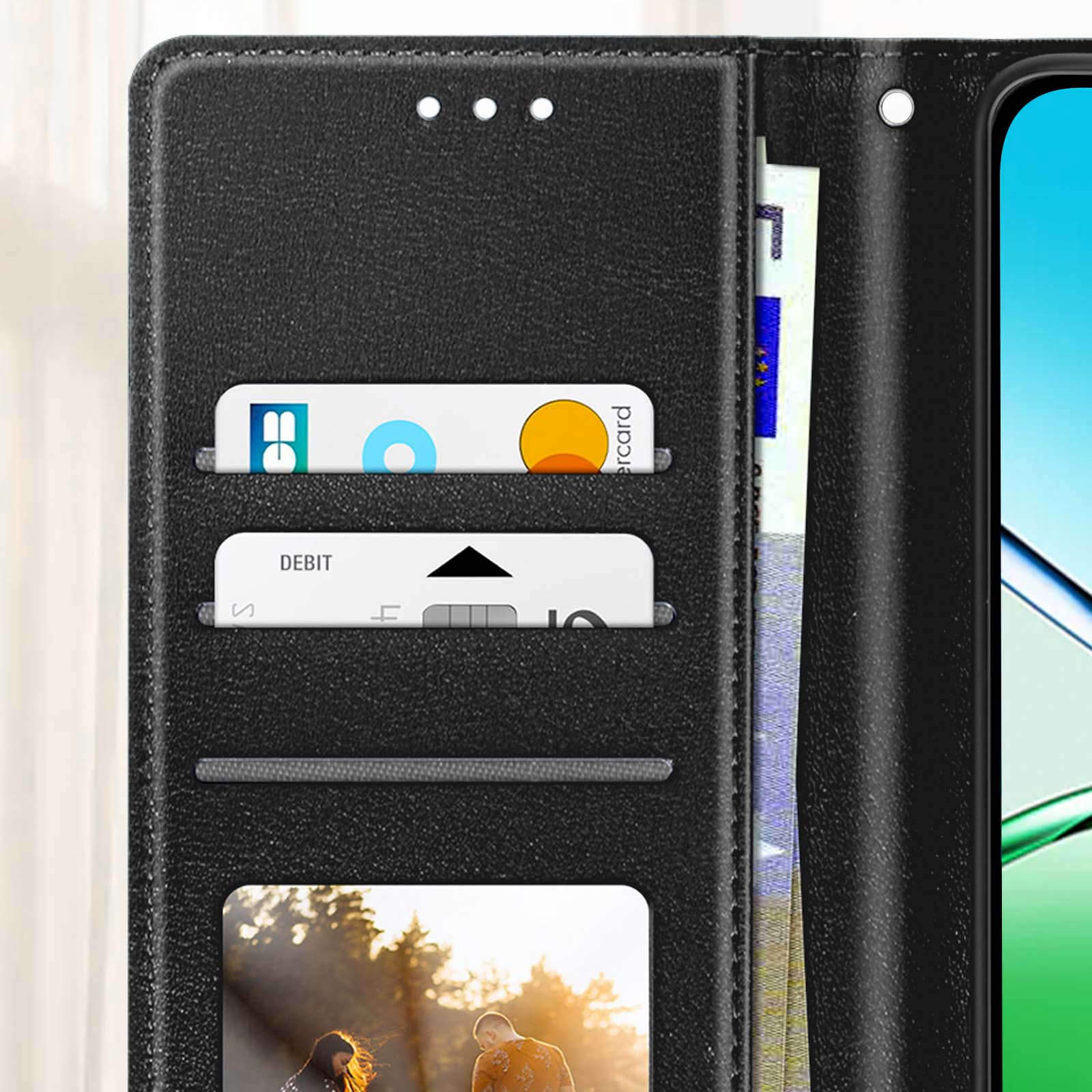 Una custodia a portafoglio in pelle nera con fessure per carte, denaro e un telefono. Carte nelle fessure, una con logo di debito. Foto nella fessura inferiore.