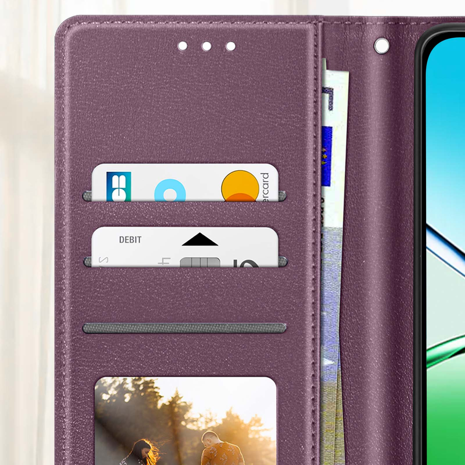 Una custodia a portafoglio viola con carte e contanti visibili. Lo schermo del telefono è a destra. Foto in basso.