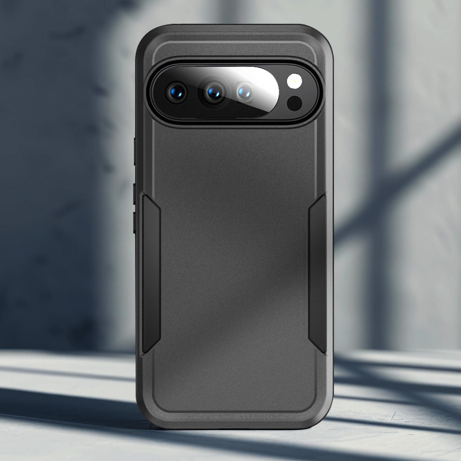 Une coque de téléphone noire avec des lentilles de caméra est sur une surface blanche. Des ombres sont projetées en arrière-plan.