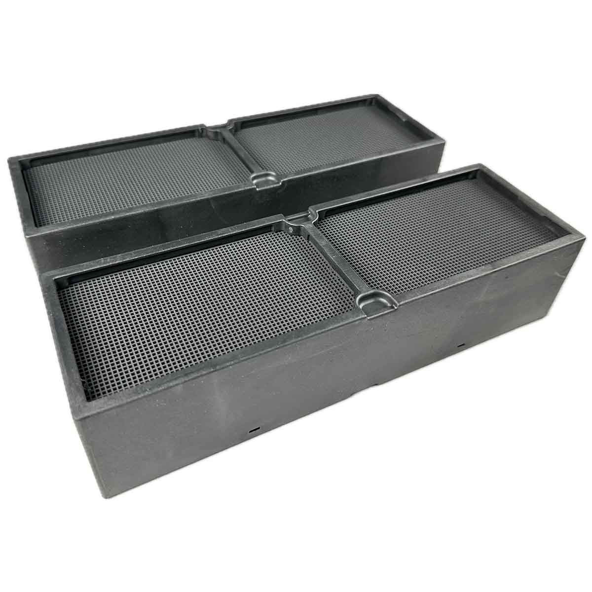 Zwei schwarze, rechteckige Objekte mit Mesh-Oberflächen. Sie liegen auf einer weißen Oberfläche. Die Objekte scheinen Luftfilter zu sein.