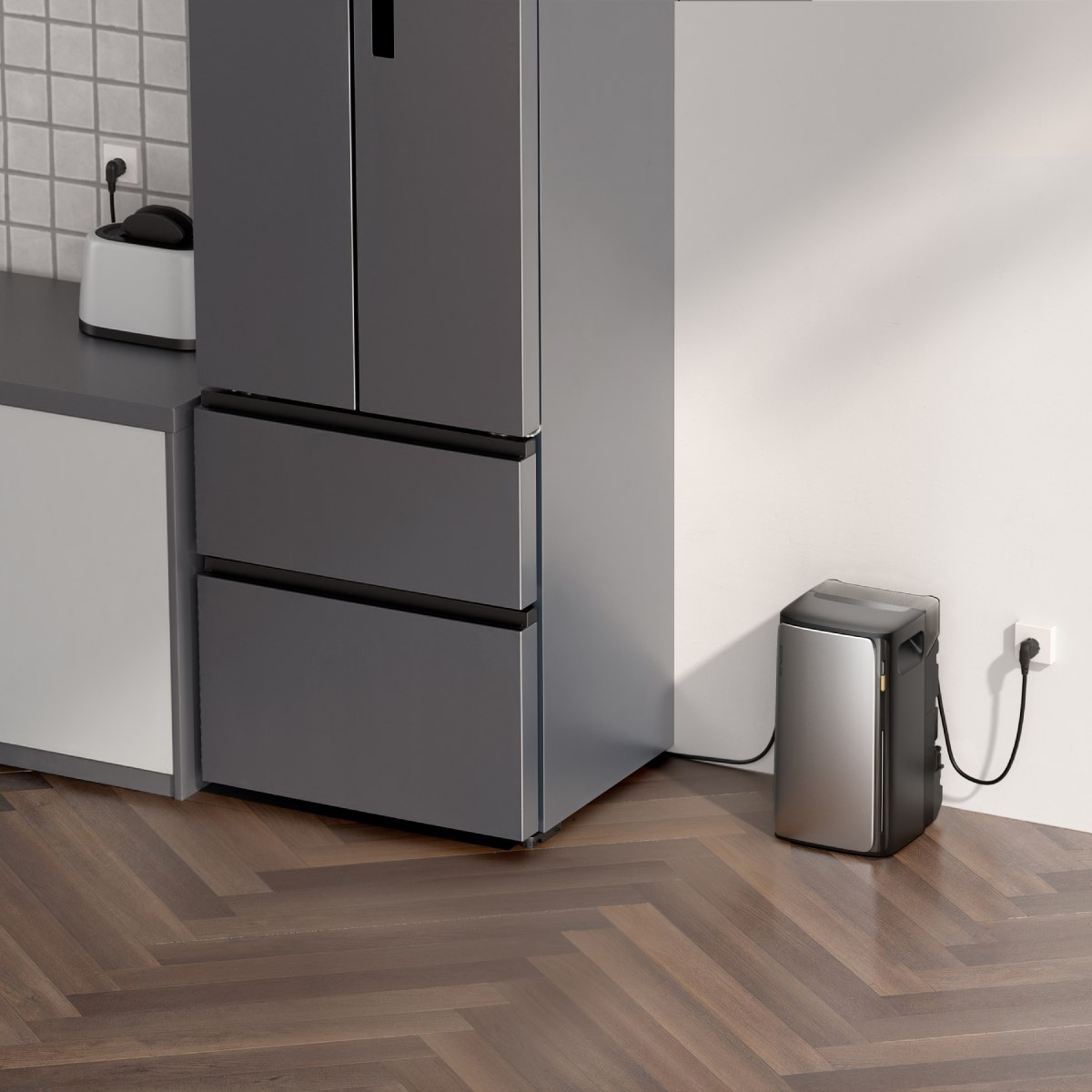 Eine moderne Küchenszene mit einem grauen Kühlschrank, einem kleinen Gerät und einem Holzboden. Eine Steckdose ist an der Wand sichtbar.