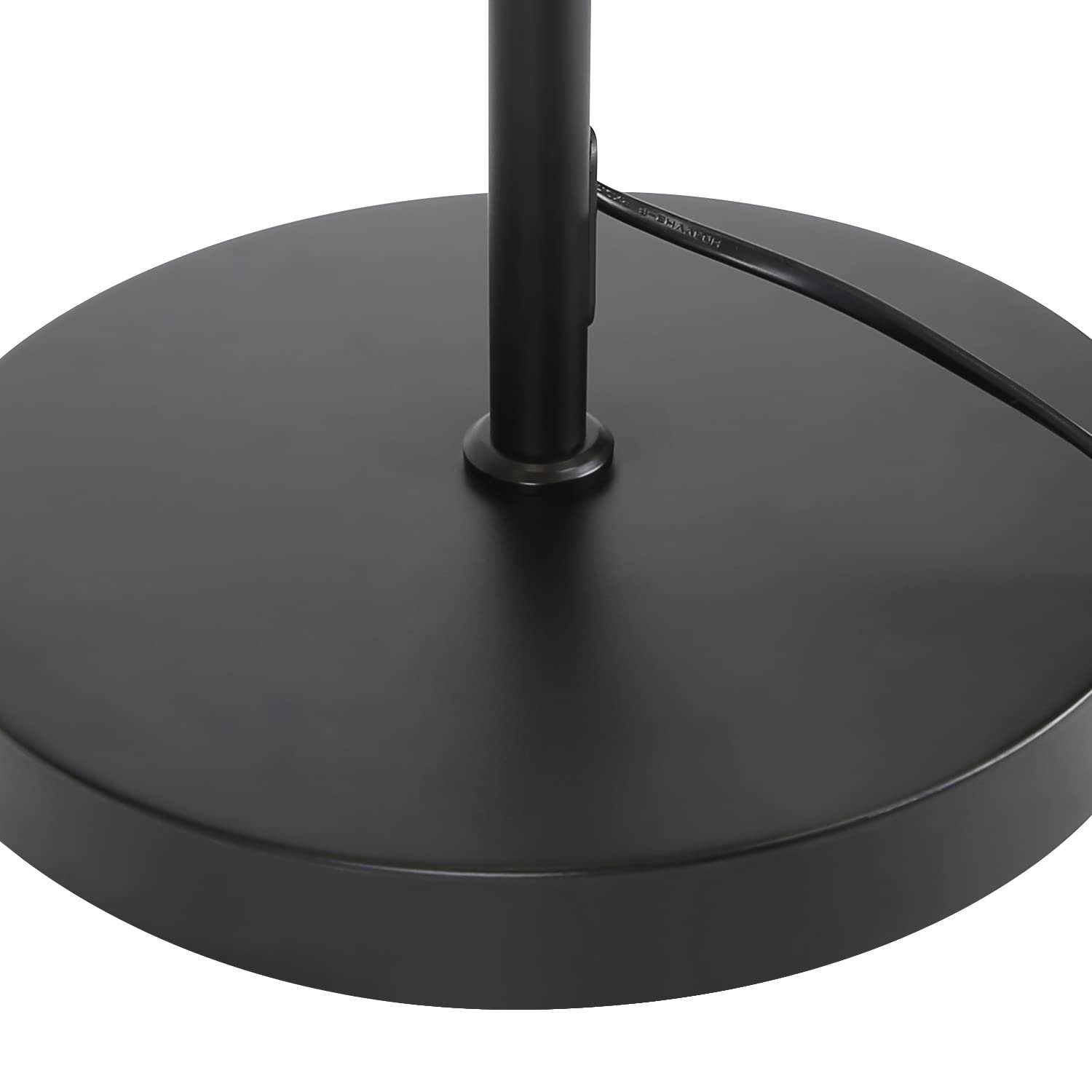 Una base per lampada da terra nera. La base è rotonda e piatta, con un palo centrale nero che si alza. Un cavo nero si estende dalla base.