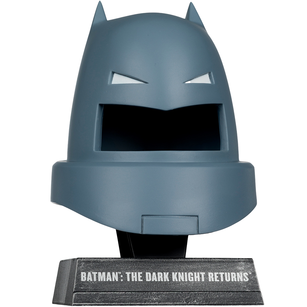 Una statua del casco di Batman. Il casco è grigio, con fessure bianche per gli occhi. Poggia su un supporto nero con la scritta "Batman: The Dark Knight Returns".