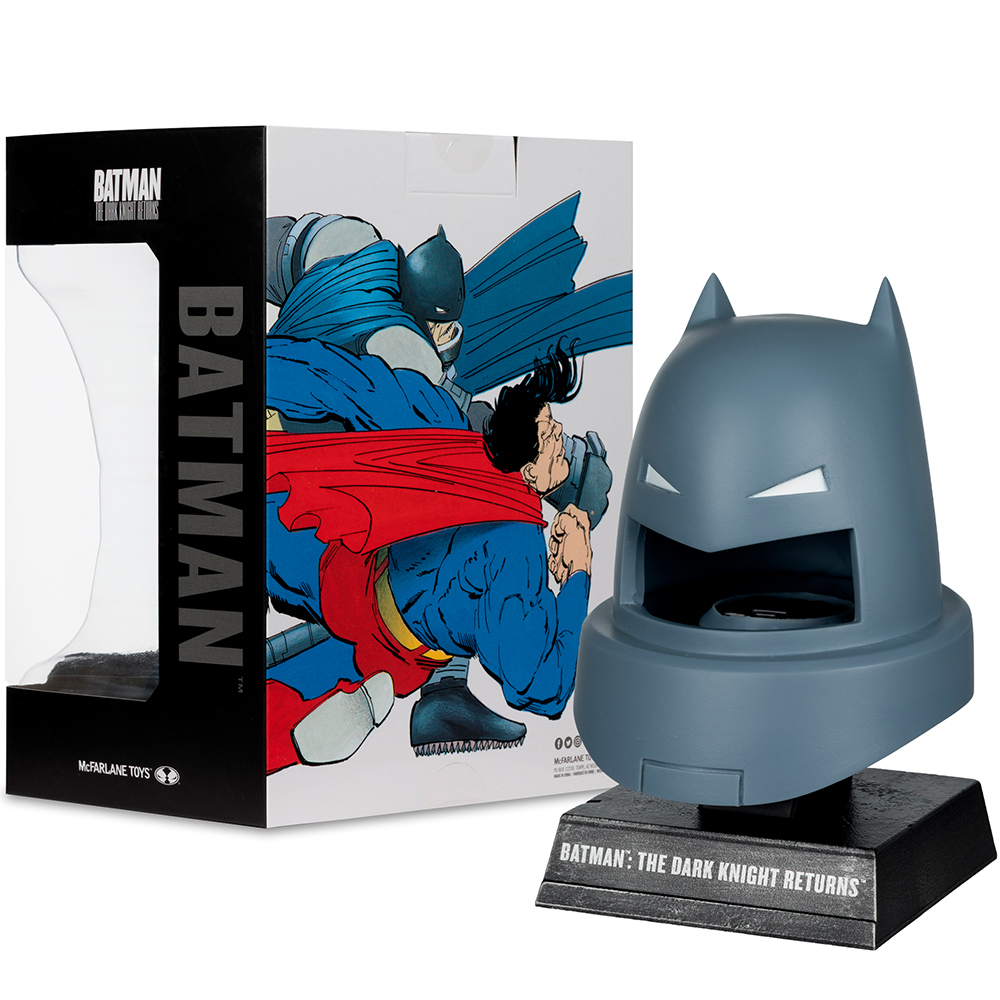 Un portaoggetti a forma di testa di Batman con l'illustrazione della scatola raffigurante Batman e Superman in combattimento. La scatola dice 'Batman: The Dark Knight Returns'.