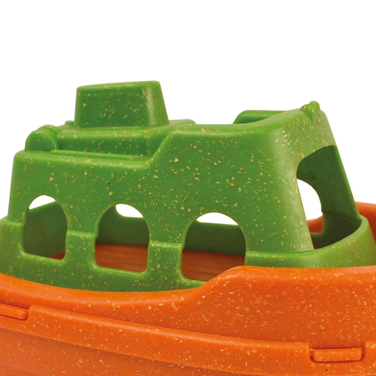 Ein Spielzeugboot mit orangefarbenem Rumpf und grüner Kabine. Die Kabine hat bogenförmige Öffnungen. Das Boot steht auf weißem Grund.