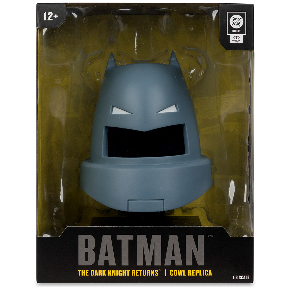 Replica del cappuccio di Batman nella confezione. Il cappuccio grigio ha fessure bianche per gli occhi ed è esposto su uno sfondo giallastro.