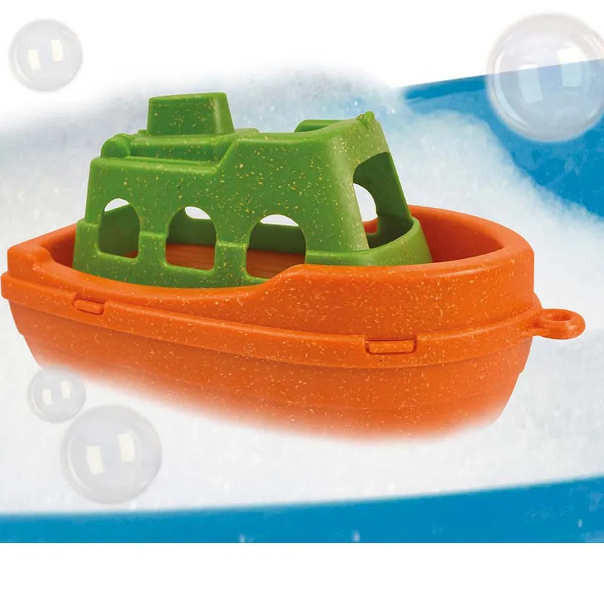 Ein orangefarbenes und grünes Spielzeugboot schwimmt in sprudelndem Wasser, im Hintergrund Blasen. Das Boot hat ein offenes Design.