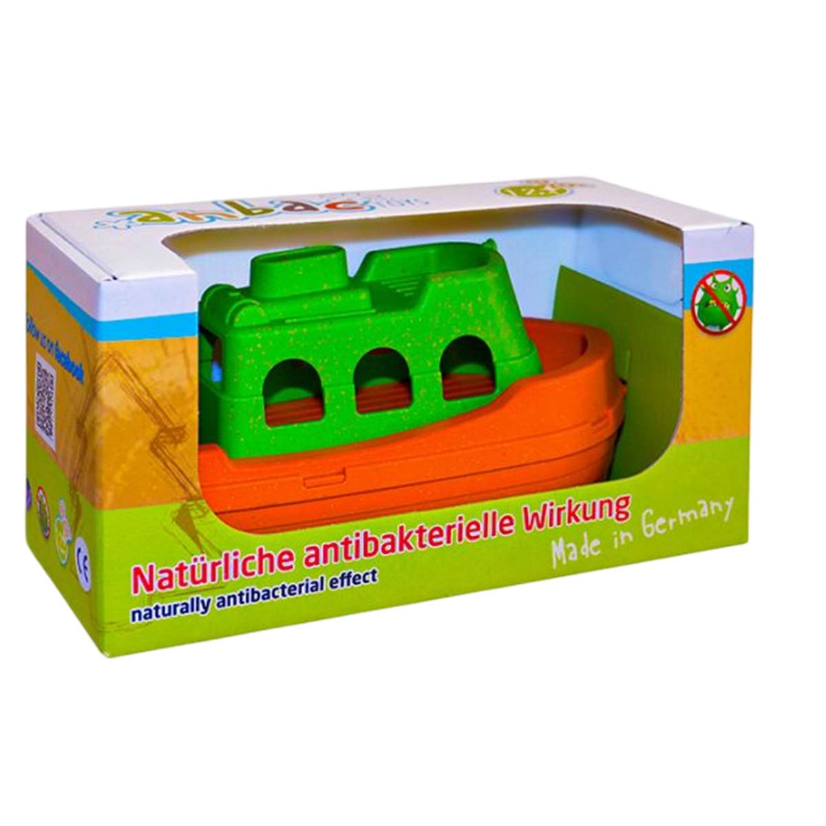 Ein Spielzeugboot in einer Box. Das Boot ist grün und orange. Auf der Schachtel steht Text auf Deutsch mit 'Made in Germany'.