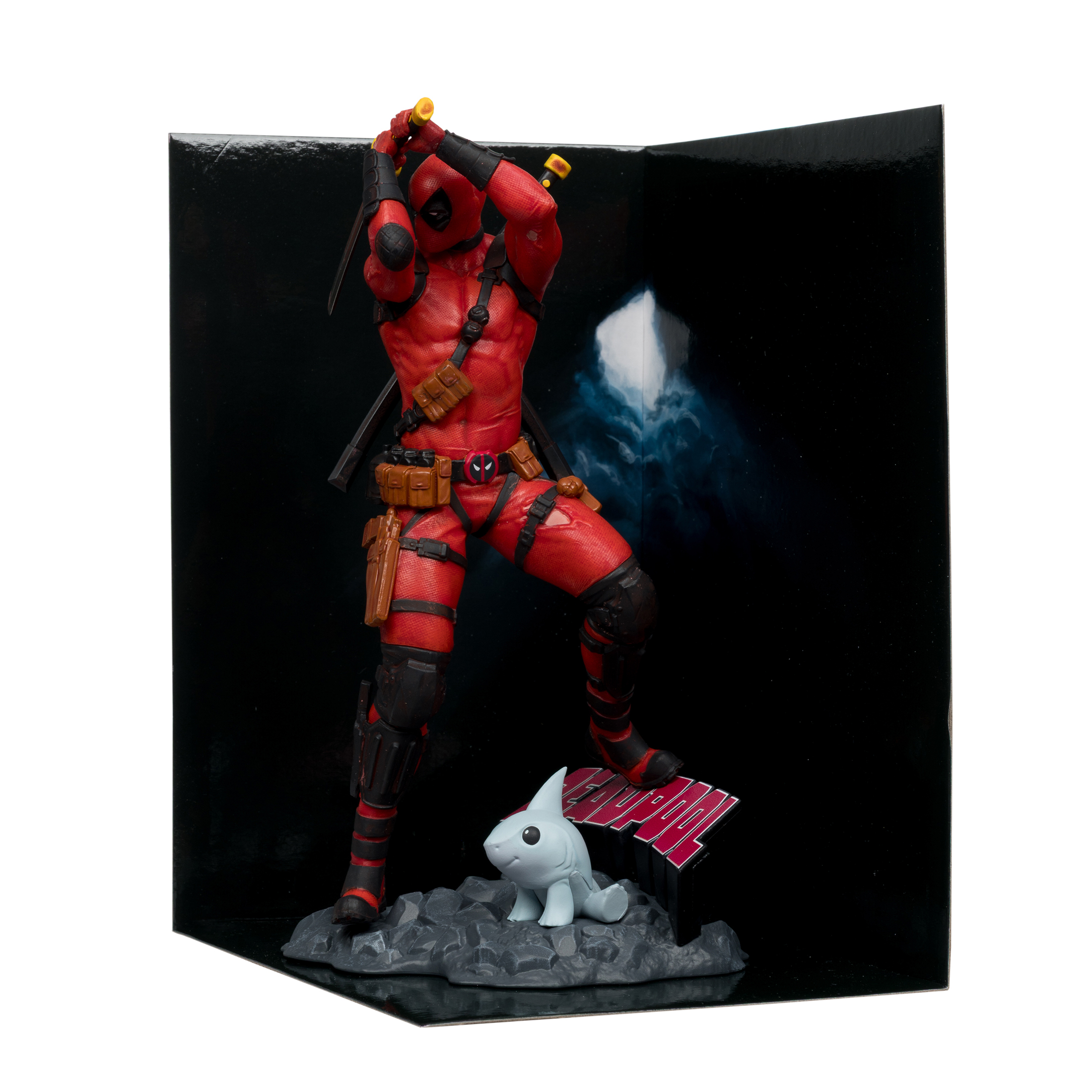 Statuetta di Deadpool con spade alzate, in posa dinamica. Una piccola statuetta di squalo ai suoi piedi. Sfondo nero.