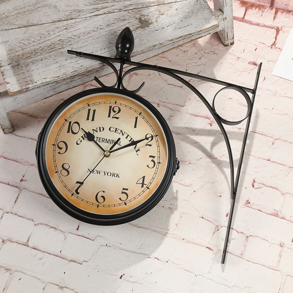 Eine schwarze, doppelseitige Uhr mit der Aufschrift Grand Central Terminal New York. Die Uhr ist an einer schwarzen Halterung befestigt.
