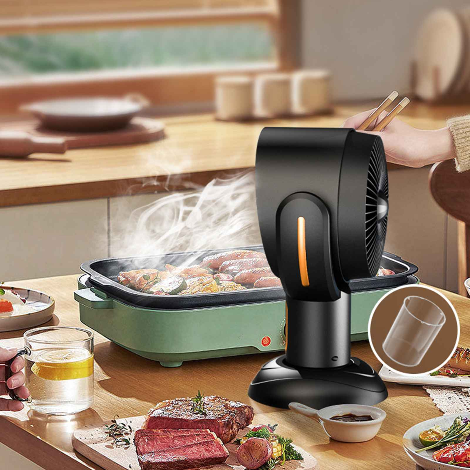 Ein Tisch mit gekochtem Essen, einem schwarzen Ventilator, einem Glas Wasser und einem Steak.