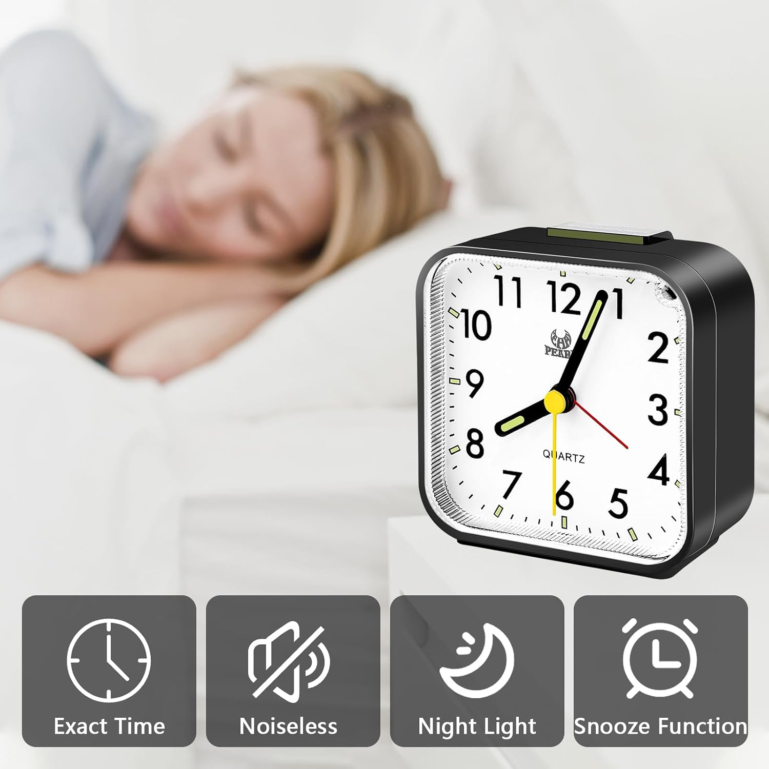 Ein schwarzer Wecker zeigt die Uhrzeit an. Eine schlafende Person im Bett ist im Hintergrund verschwommen. Symbole unten zeigen Funktionen.