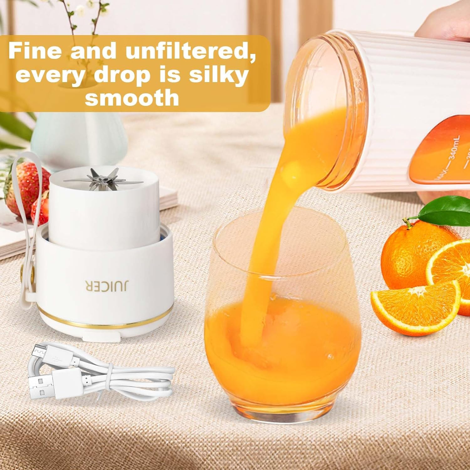 Orangensaft wird in ein Glas gegossen. Ein Mixer, Orangen und ein USB-Kabel sind ebenfalls auf einer Tischdecke zu sehen.