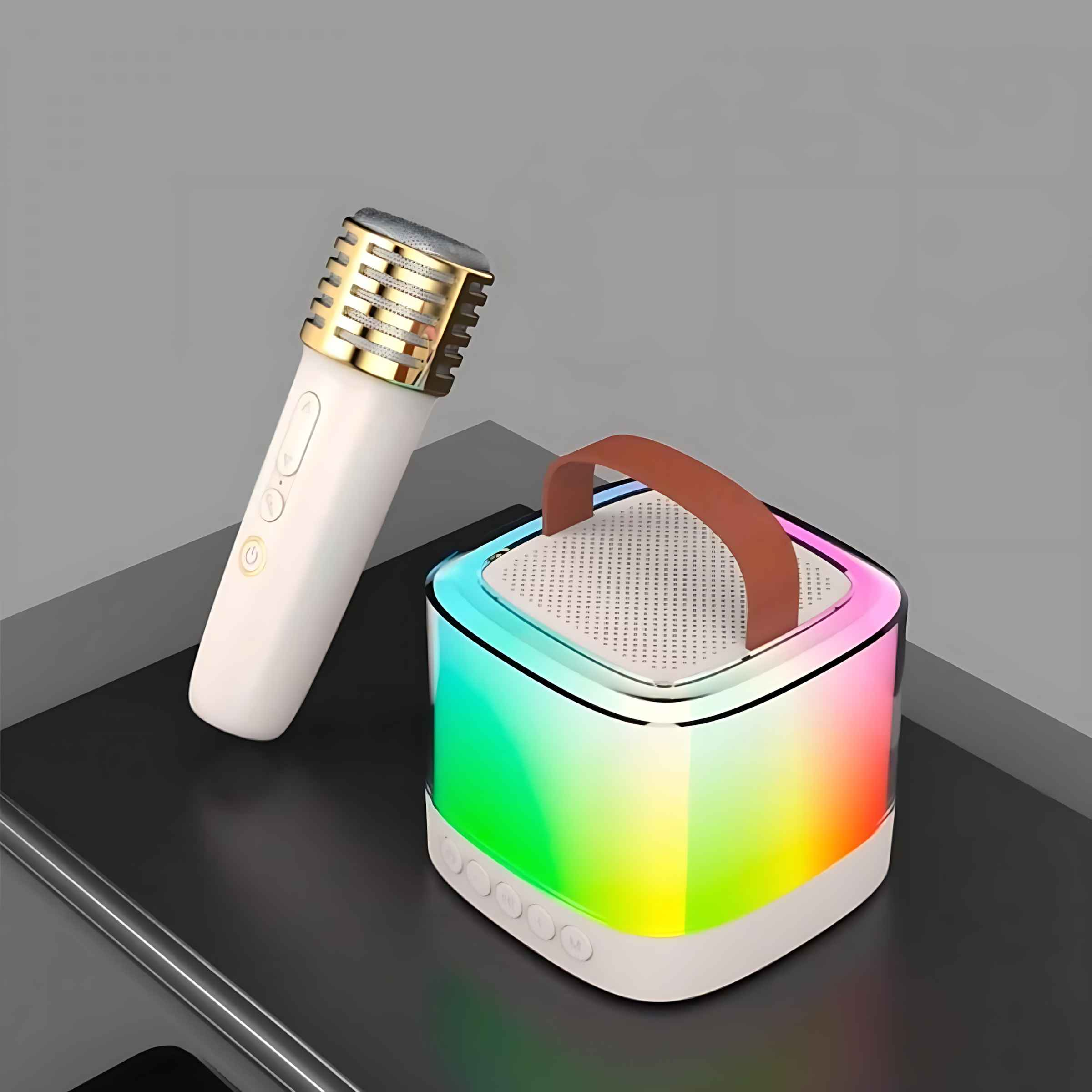 Ein weißes Mikrofon mit goldenem Kopf neben einem Würfel-Lautsprecher mit Regenbogenlichtern. Beide auf dunkler Oberfläche.