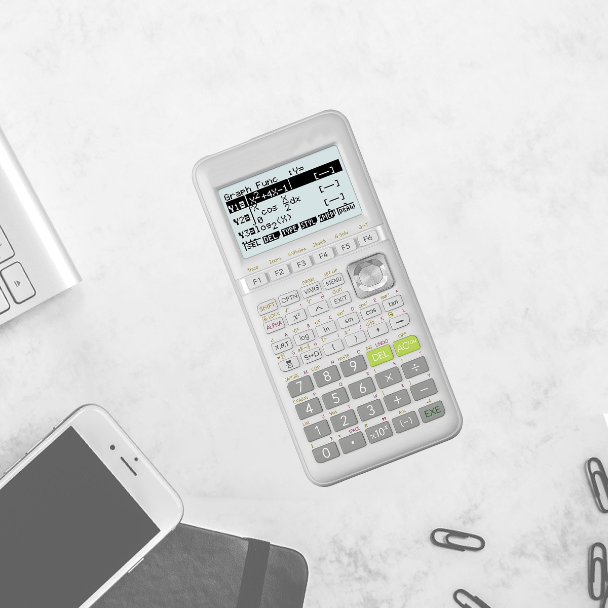 Ein Taschenrechner zeigt Gleichungen auf einem Bildschirm an. Ein Telefon, eine Tastatur und Büroklammern liegen auf der weißen Oberfläche.