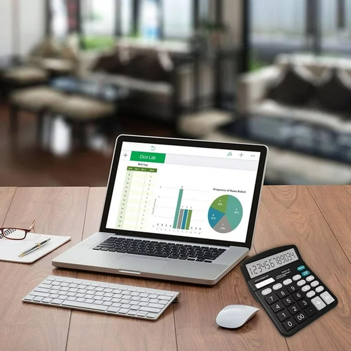 Laptop auf einem Holzschreibtisch zeigt Diagramme. Tastatur, Maus, Taschenrechner, Stift und Brille sind in der Nähe. Der Hintergrund hat unscharfe Möbel.