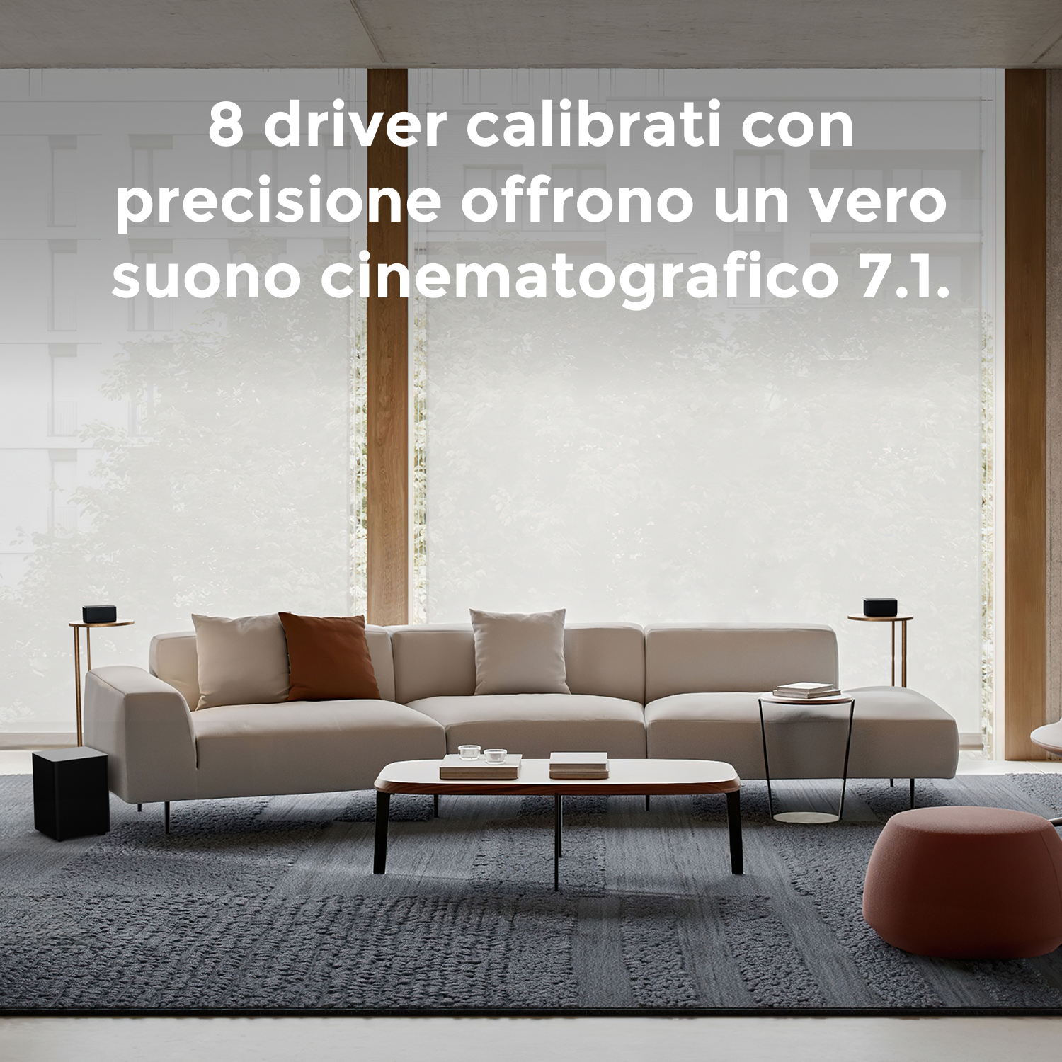 Soggiorno con divano color crema, tappeto grigio, tavolino e altoparlanti. Testo: 8 driver calibrati con precisione...