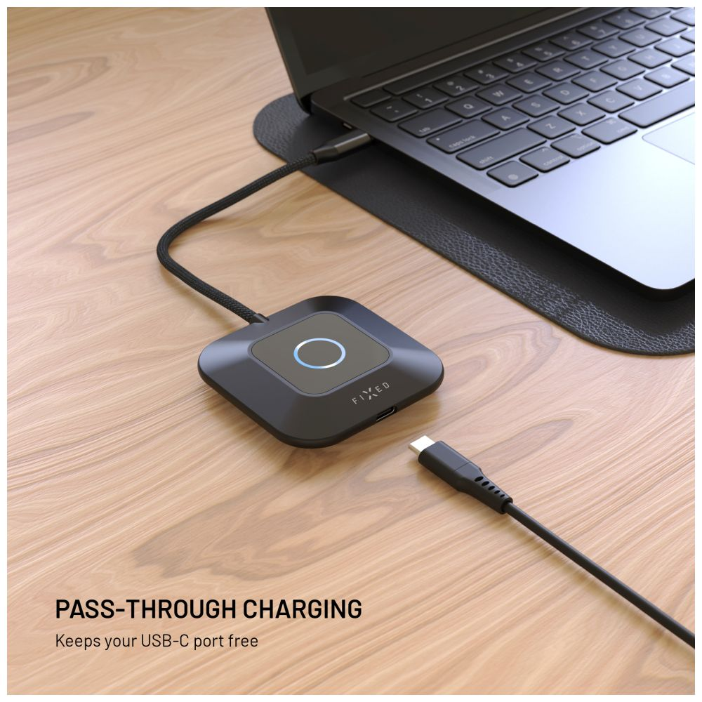 Ein schwarzer Laptop und ein Ladegerät auf einer Holzoberfläche. Ein USB-C-Kabel ist mit dem Laptop und dem Gerät verbunden.