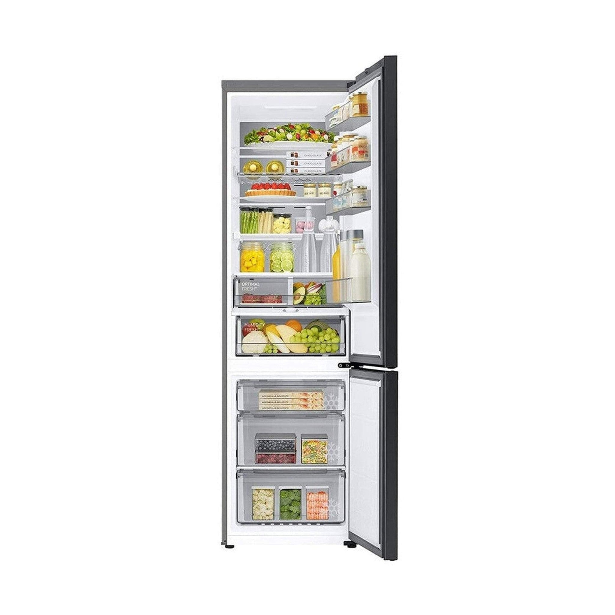 Un réfrigérateur ouvert rempli de nourriture. Il possède plusieurs étagères avec fruits, légumes, bocaux et contenants visibles.