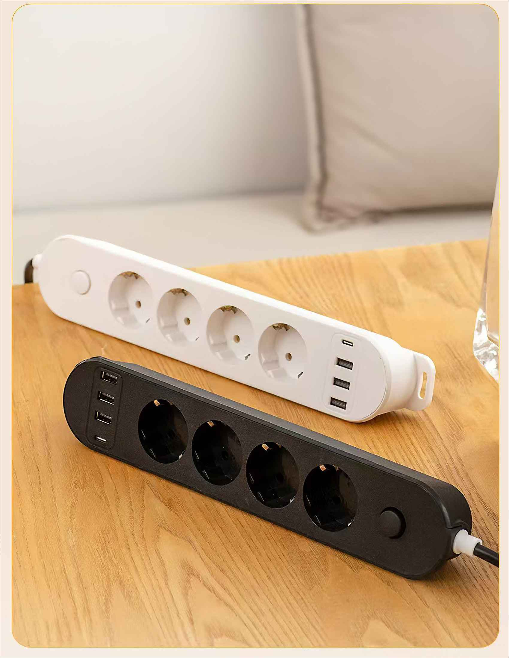 Zwei Steckdosenleisten, weiß und schwarz, auf einem Holztisch. Die weiße hat Steckdosen und USB-Anschlüsse. Die schwarze hat Steckdosen.